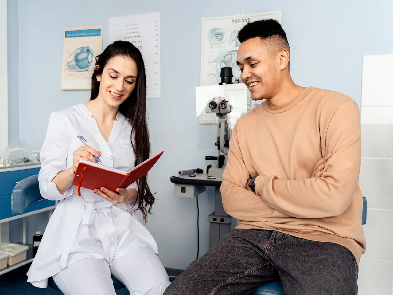 Stock photo: a clinician taking notes while talking with a patient in a clinic room